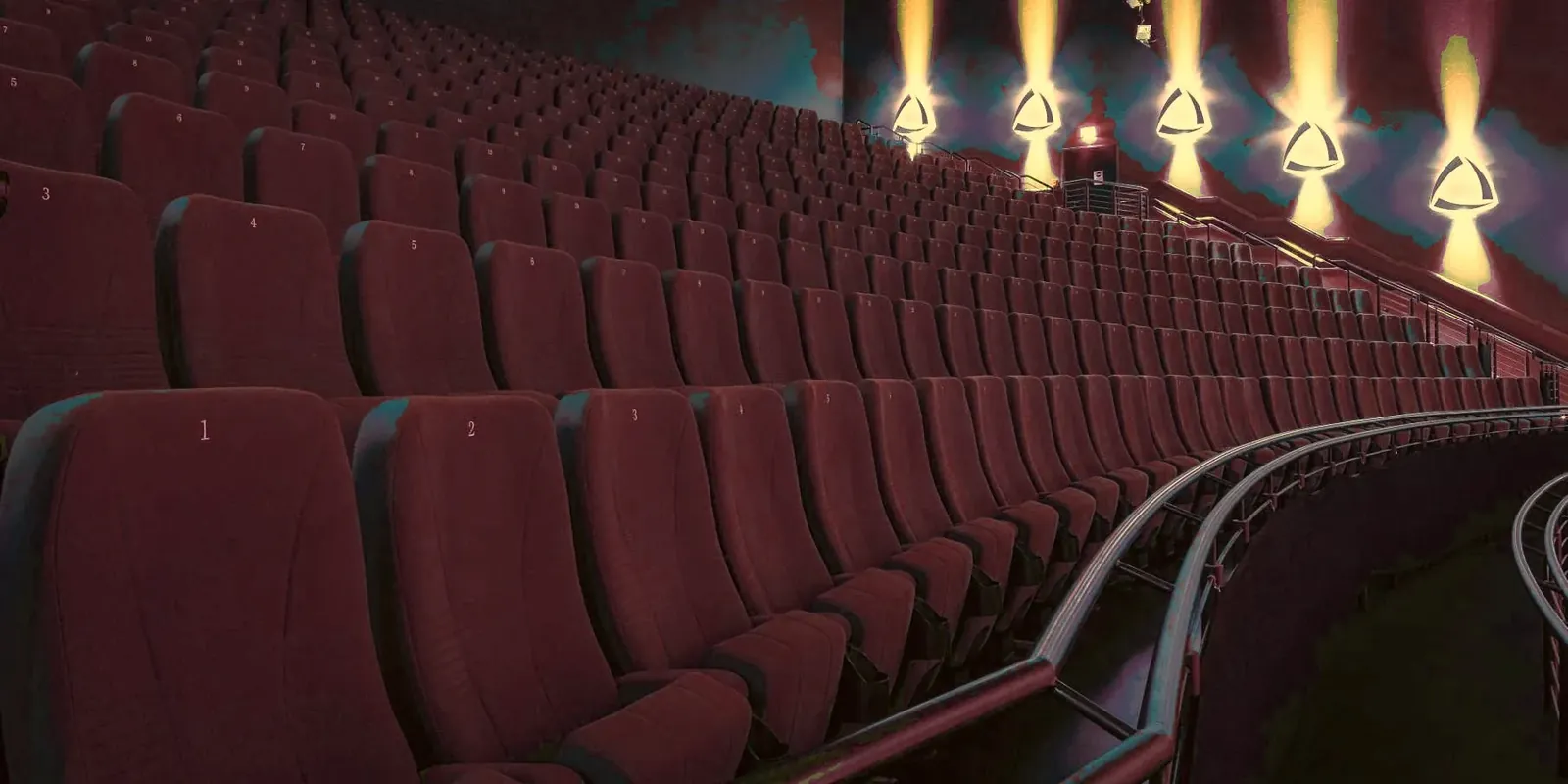 Rows of burgundy cinema recliners facing the screen in a treated multiplex auditorium