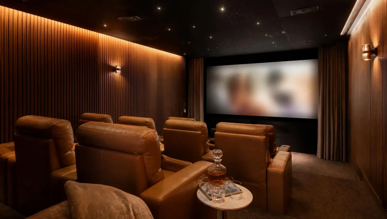 Private home cinema with leather recliners, warm cove lighting and acoustic slat walls